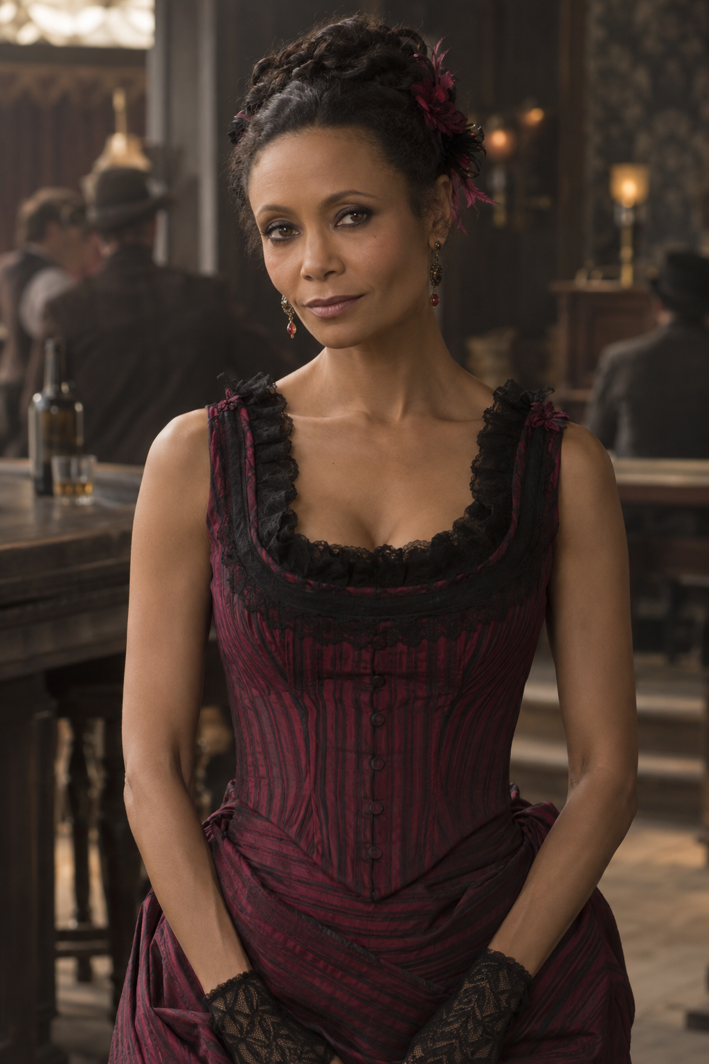 Thandiwe Newton as Maeve Millay, wearing a burgundy period dress with black lace trim in a softly lit saloon.