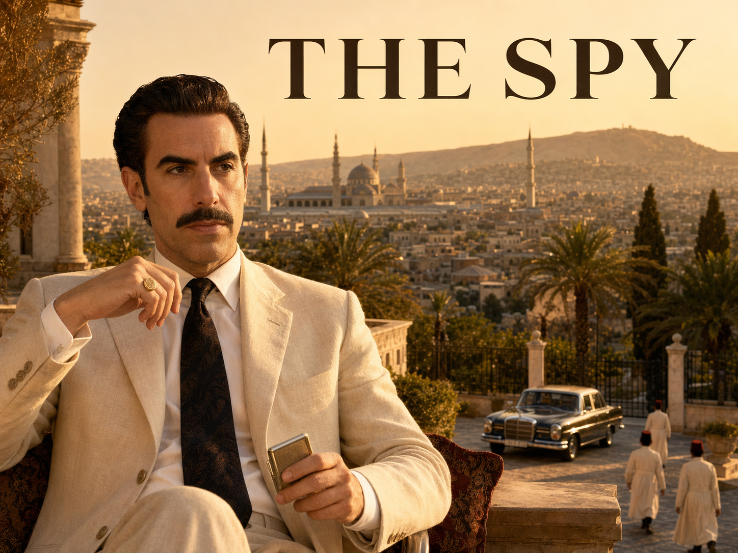 Sacha Baron Cohen as Eli Cohen in a cream linen suit with a dark tie on a 1960s Damascus villa terrace with the city and Umayyad Mosque minarets in the background, The Spy title overlay.